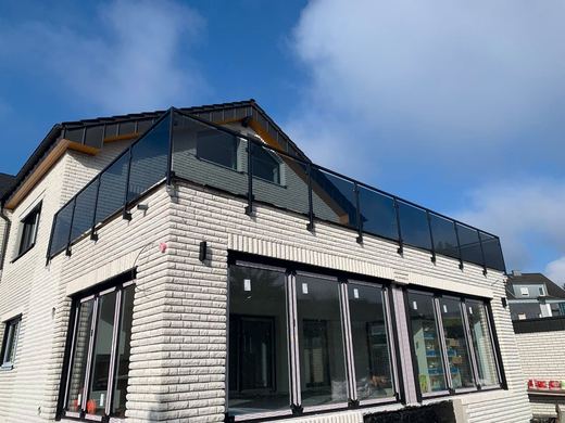 Dachterrassengeländer mit Grauglas an einem Neubau